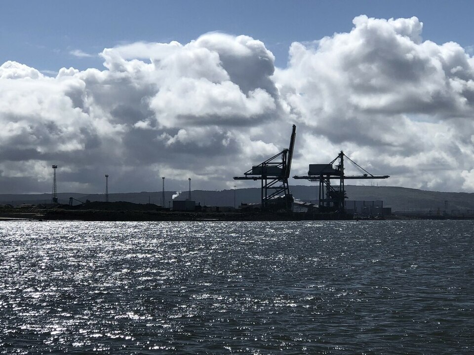 Cranes in silhouette at Teesport; illustrative port location image, not the record corn delivery.