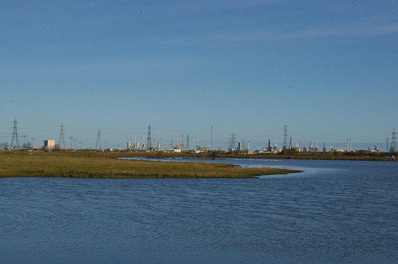 Archive photograph across a pond at RSPB Saltholme towards industrial buildings at Seal Sands