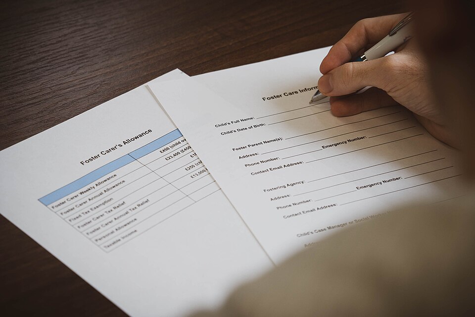 Archive photograph showing a person completing foster-care paperwork. It does not show Darlington's new training programme.