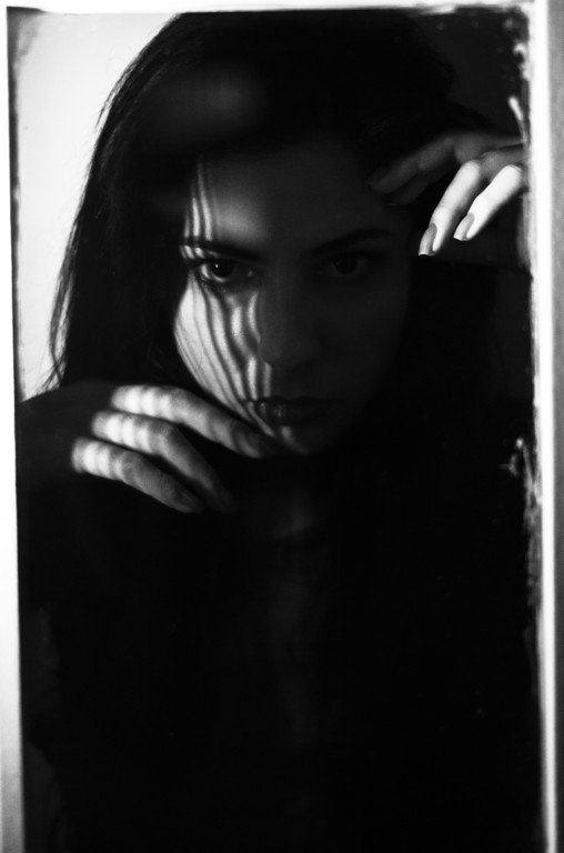 Retrato sensual em preto e branco, rosto marcado por sombra de veneziana