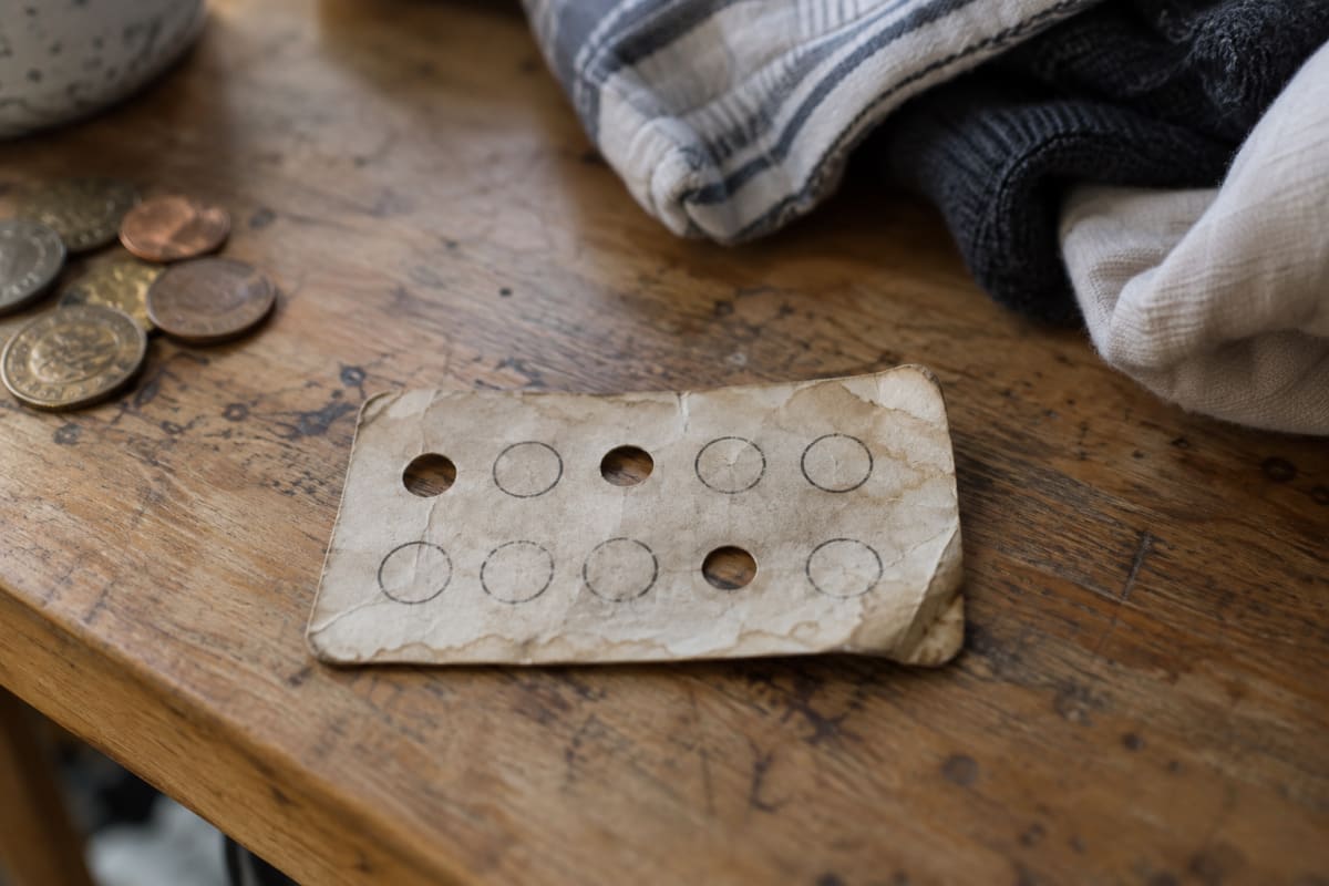A worn paper punch card, faded from a trip through the wash