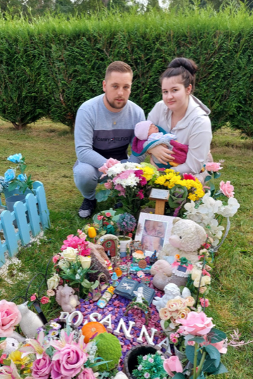 Elena, David and their new baby next to Rosanna's grave