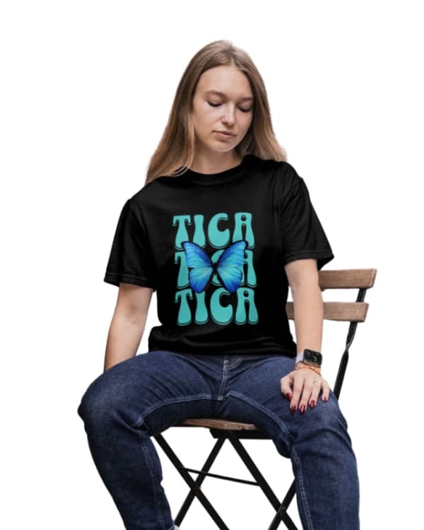 Camiseta unisex negra con diseño de mariposa azul y texto "TICA" en color aqua