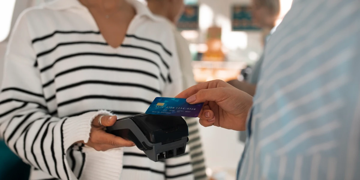 Close‑up of a contactless credit card terminal with a card being tapped for payment