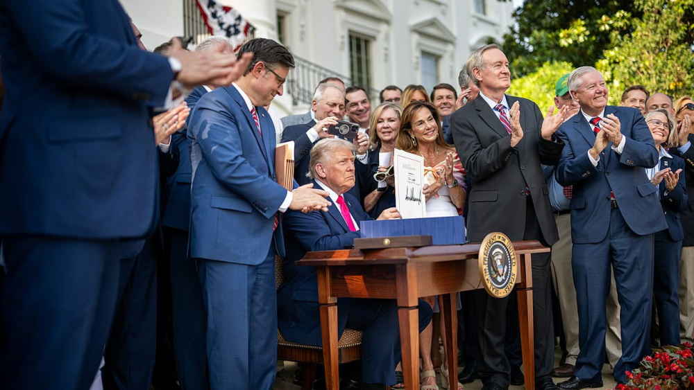 U.S. President signs major education finance reform into law, surrounded by lawmakers—symbolizing enactment of new federal student loan limits under the OBBB.