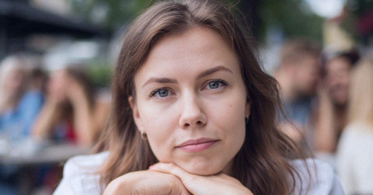Luova tekijä istuu kuulokkeet päässään työpöydän ääressä ystävien kannustaessa hänen takanaan.