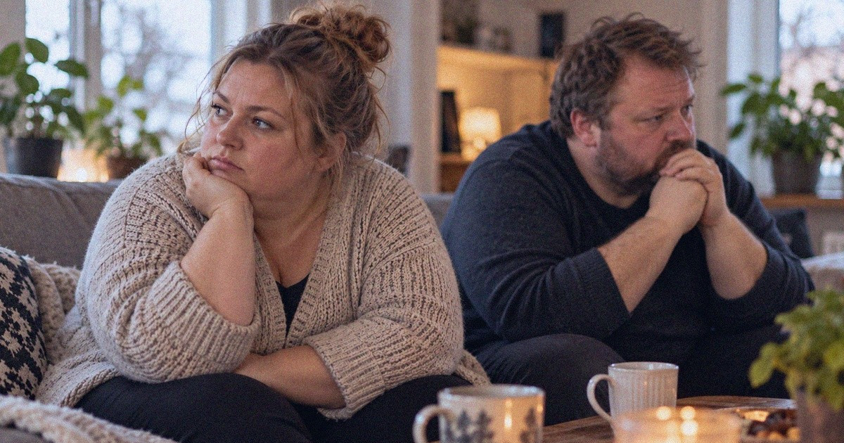 Pariskunta keskustelee olohuoneen sohvalla.