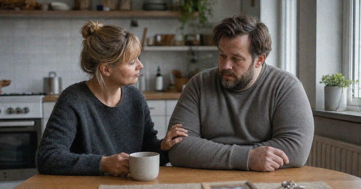 Kaksi ihmistä keskustelee rauhallisesti keittiönpöydän ääressä perhekuvan ja avainten ollessa taustalla.
