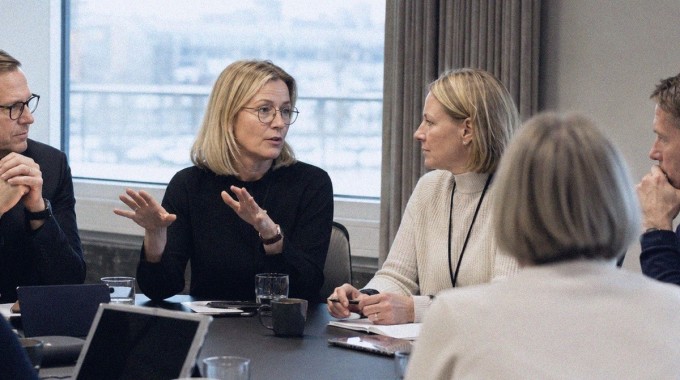 Naiset ja miehet osallistuvat pörssiyhtiön hallituksen kokoukseen.