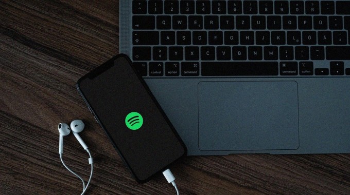 Kuuntelija muokkaa henkilökohtaista uutuusmusiikin soittolistaa puhelimella ja tietokoneella.