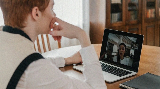 Mies kannettavalla tietokoneella videopuhelussa.