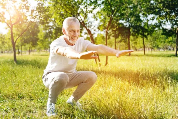 An old man doing squat