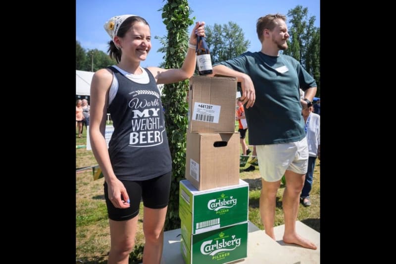 Un couple sourie à la victoire en ouvrant les cartons de bières offerts aux gagnant du Wife Carrying World Championship.