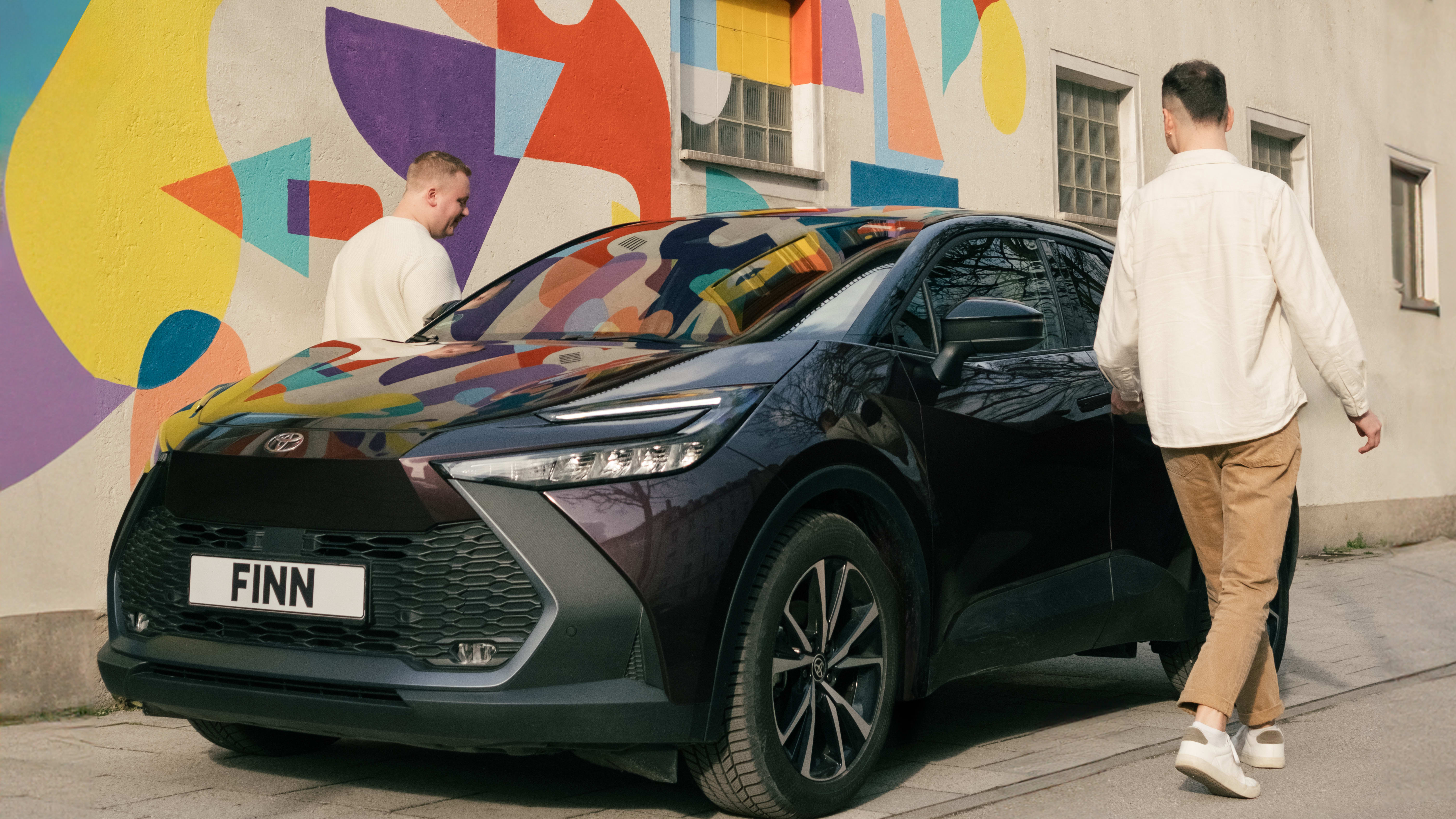 Zwei Männer steigen in einen Toyota C-HR von FINN.
