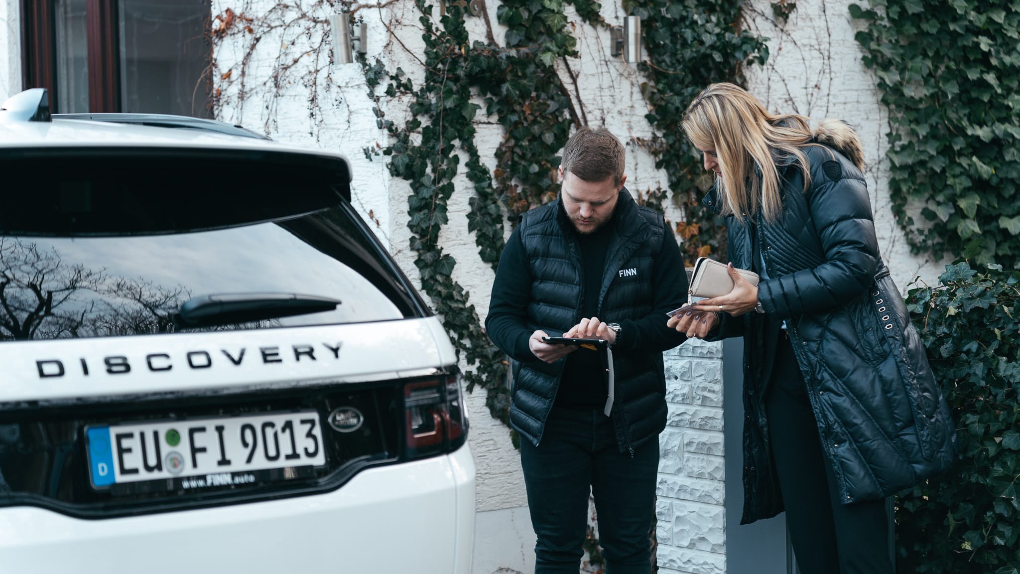 Ein Mann und eine Frau stehen neben einem Jeep von FINN.