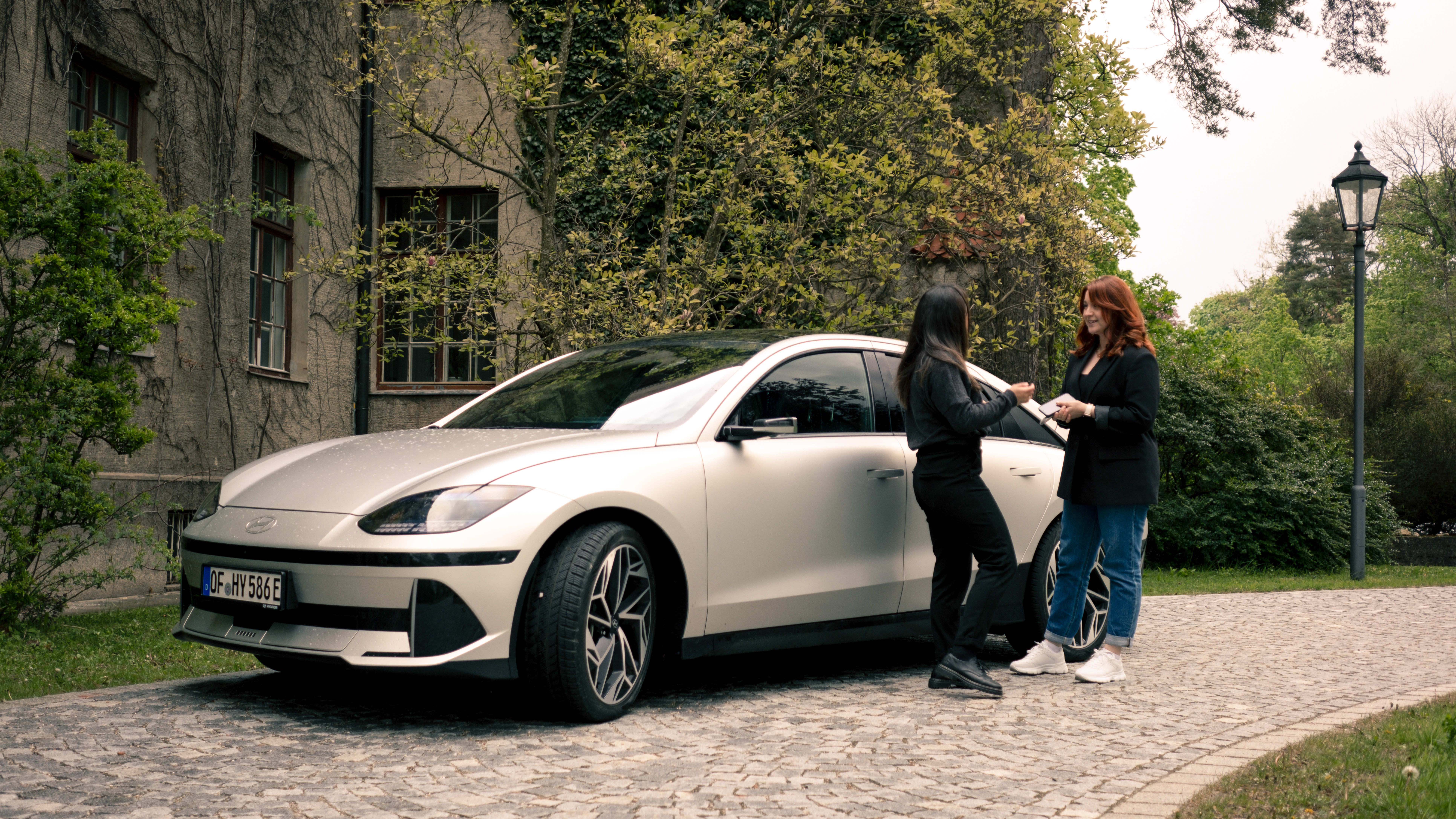 Zwei Frauen stehen neben einem Hyundai IONIQ 6 von FINN.