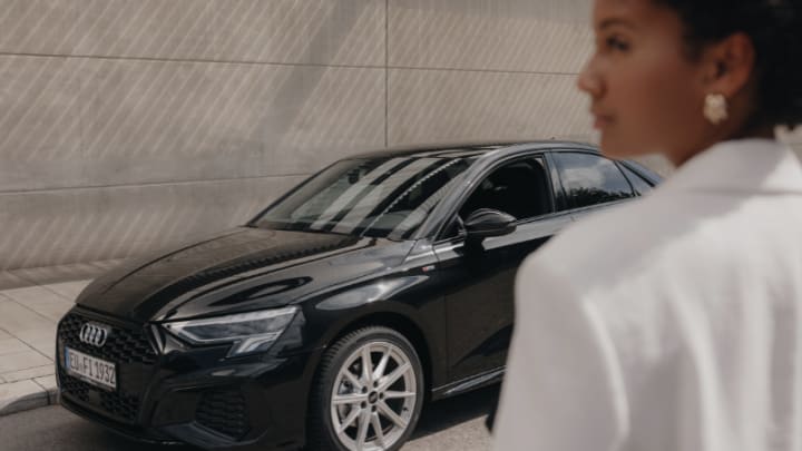 Frau steht vor Audi A3 Limousine von FINN.