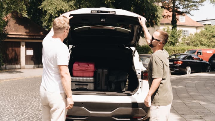 Zwei Männer stehen bei einem Auto.