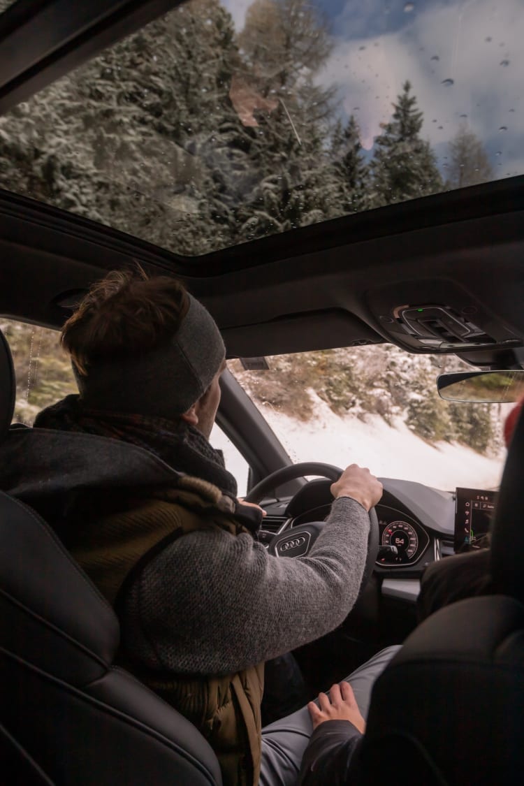 Ein Mann fährt im Winter Auto.