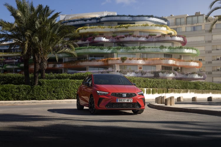 Roter SEAT Ibiza FR vor bunten Balkonen.