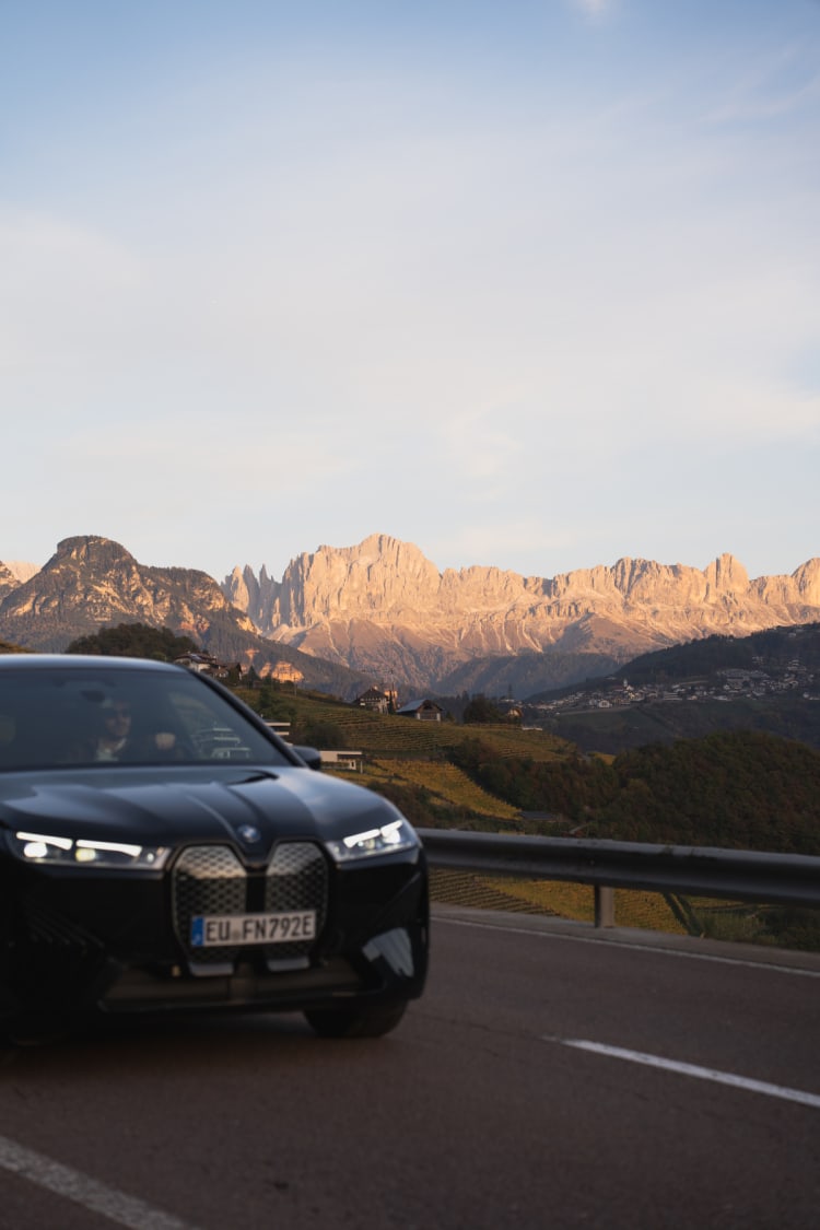 Ein BMW iX fährt durch eine Berglandschaft.
