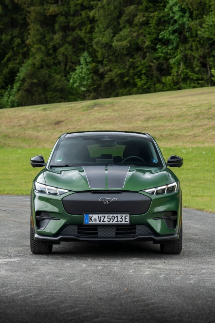 Grüner Ford Mustang Mach-E auf einer Straße.