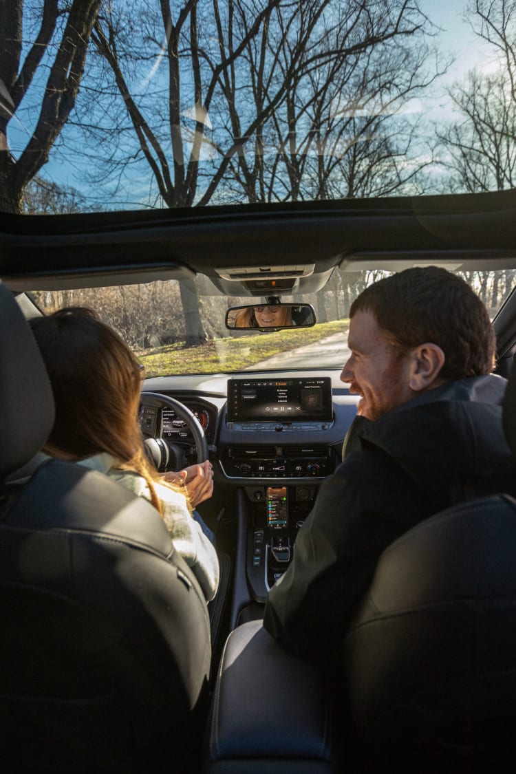 Zwei Personen sitzen glücklich in einem Nissan Q