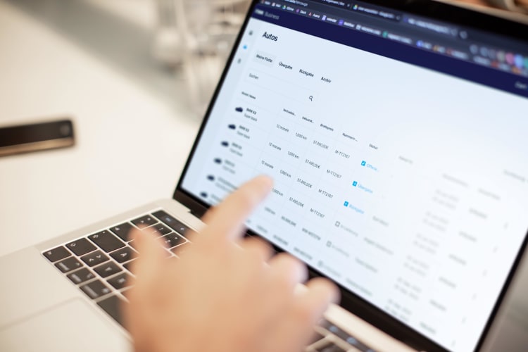 Hand zeigt auf einen Laptop-Bildschirm