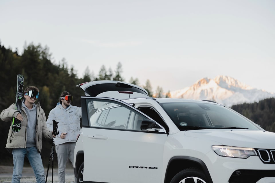 SUV vor einer Alpenlandschaft.