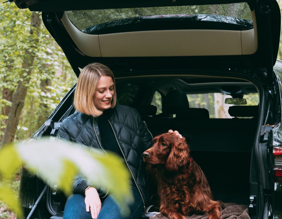 Frau und Hund sitzen in dem Kofferraum eines BMW X5 von FINN