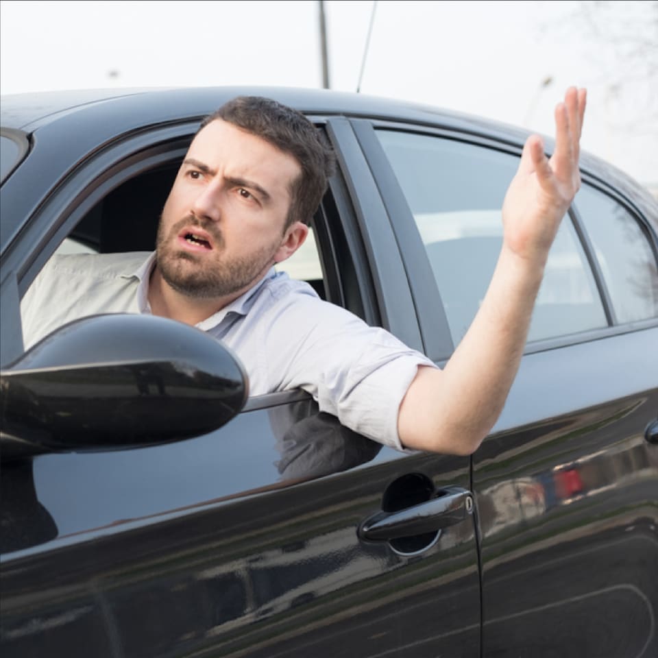 A man is inside a car and encounters a road rage. 