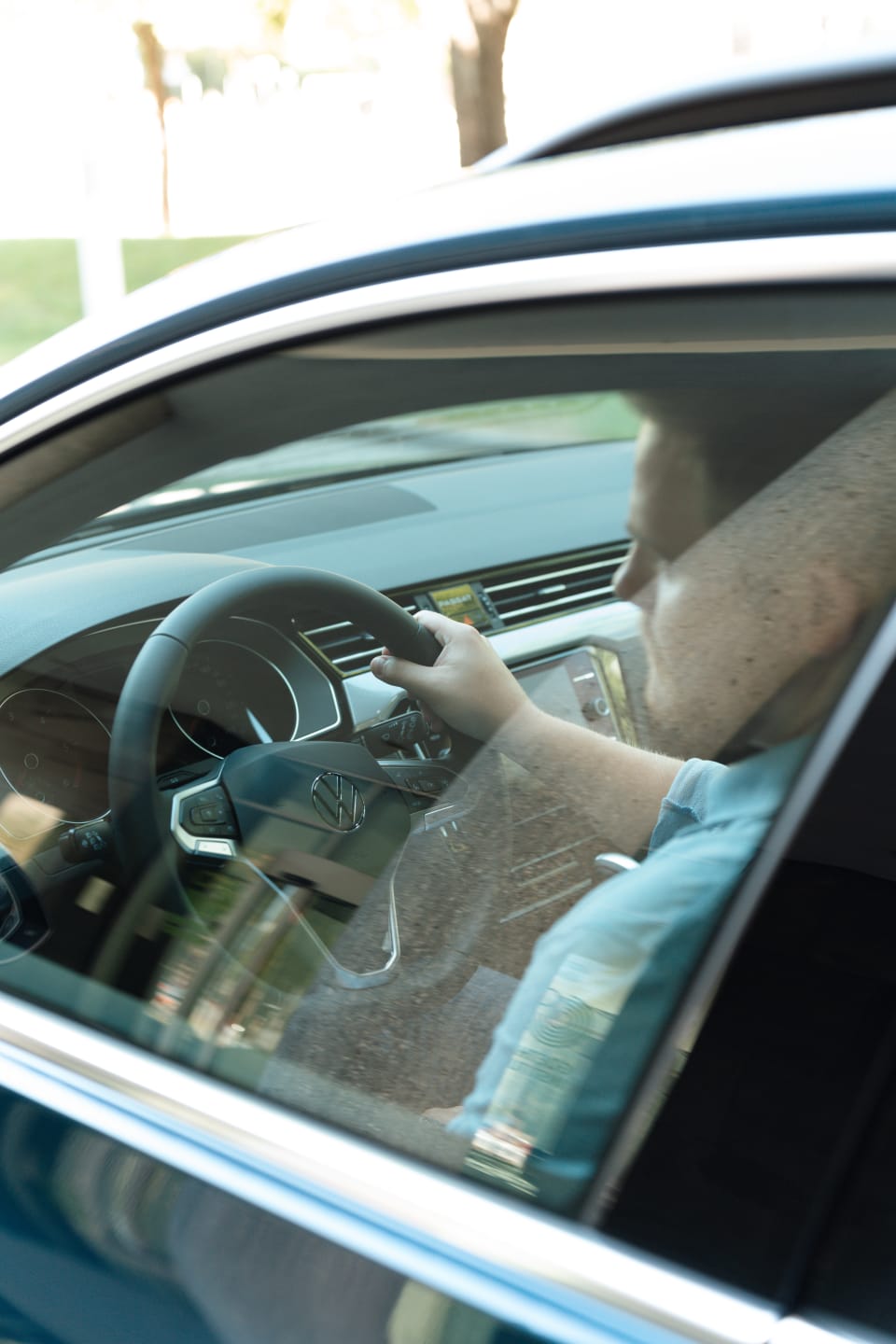Ein Mann sitzt am Steuer eines VW Passats.