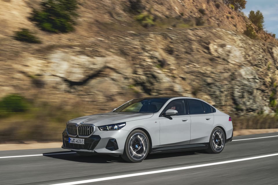 Die BMW i5 Limousine fährt auf der Straße.