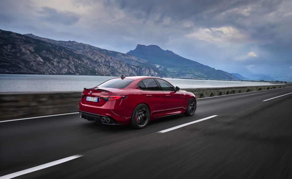 Ein roter Alfa Romeo fährt auf der Straße.