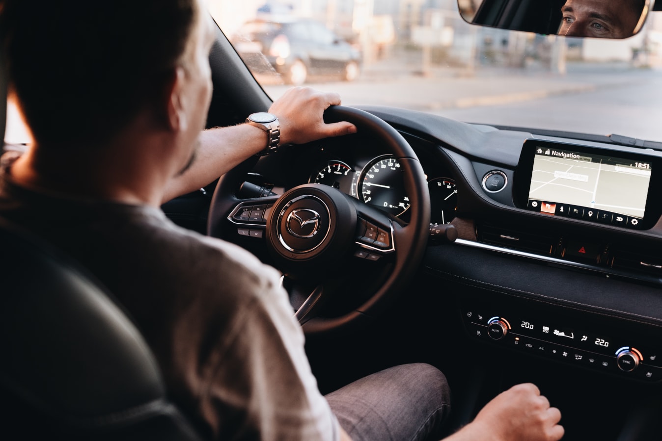 Ein Mann sitzt am Steuer eines Mazda.