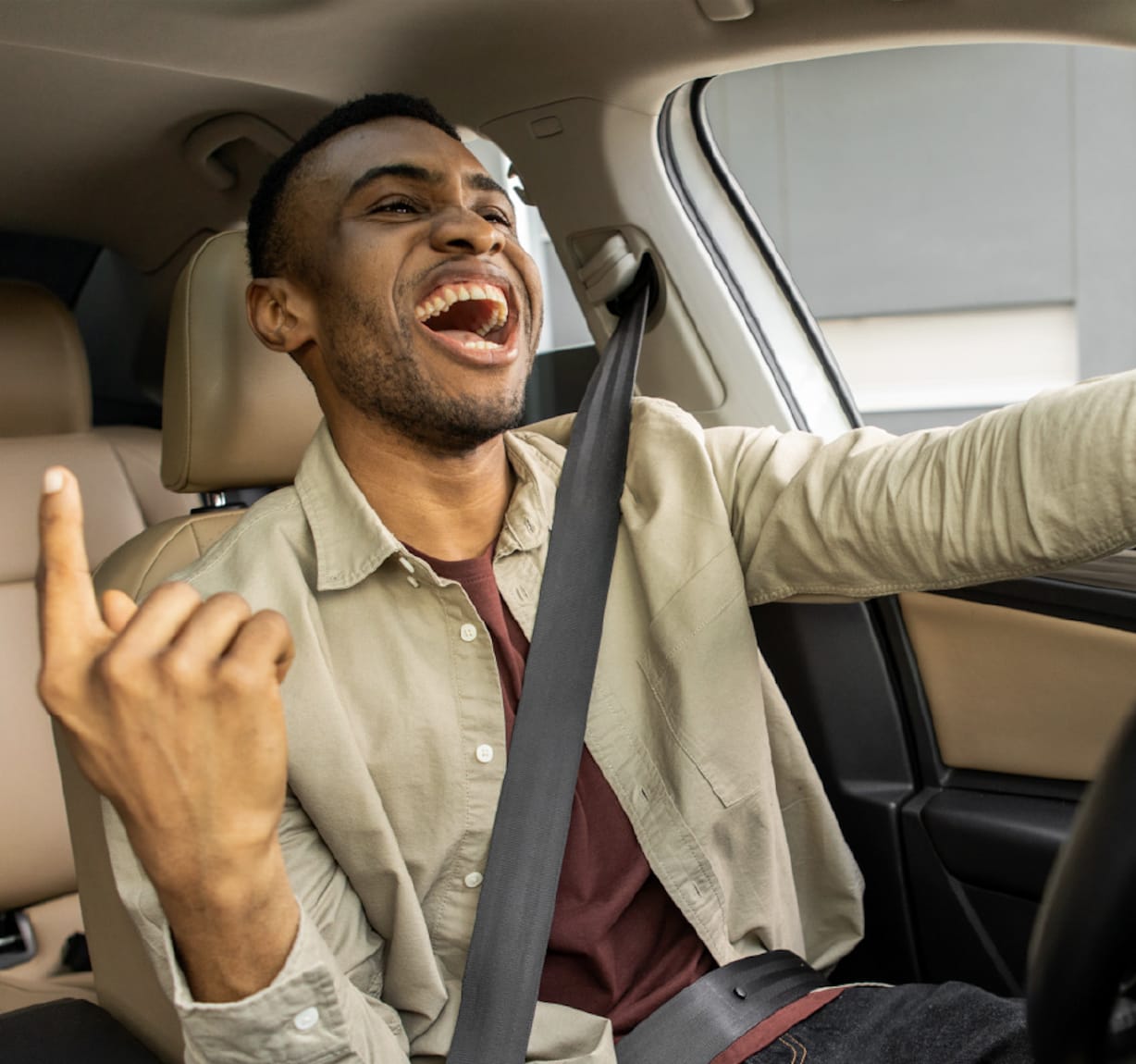 Ein Mann hört beim Autofahren Musik.