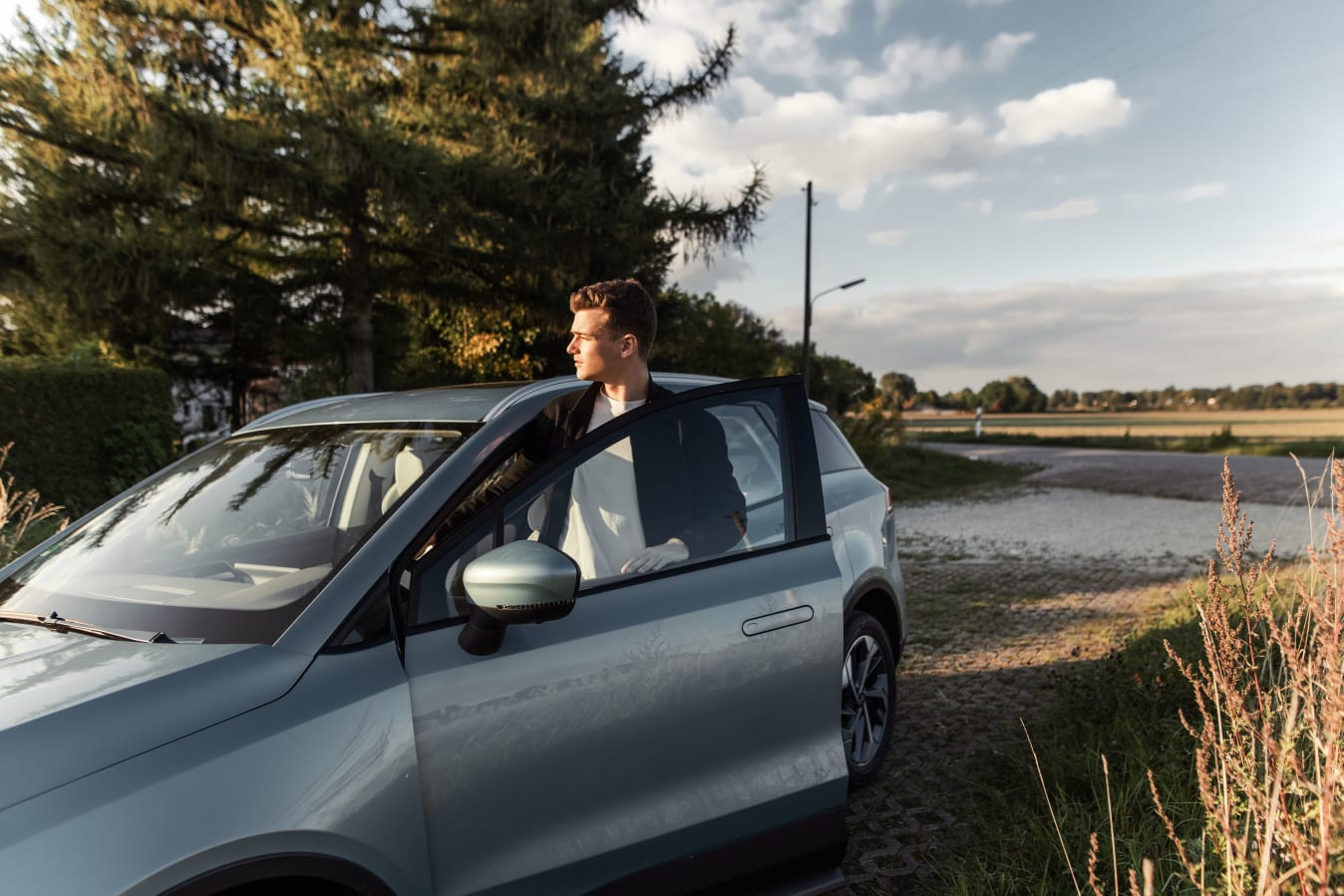 Mann steigt in sein graues FINN Auto ein.