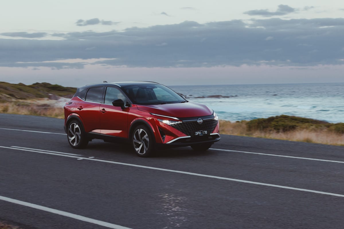 Ein roter Nissan Qashqai auf einer Küstenstraße.