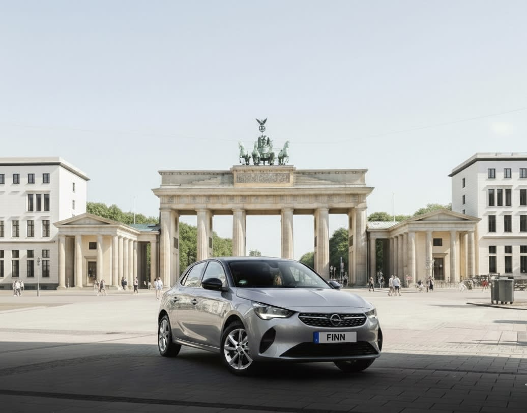 Eine Hand am Lenkrad mit dem Berliner Fernsehturm im Hintergrund.