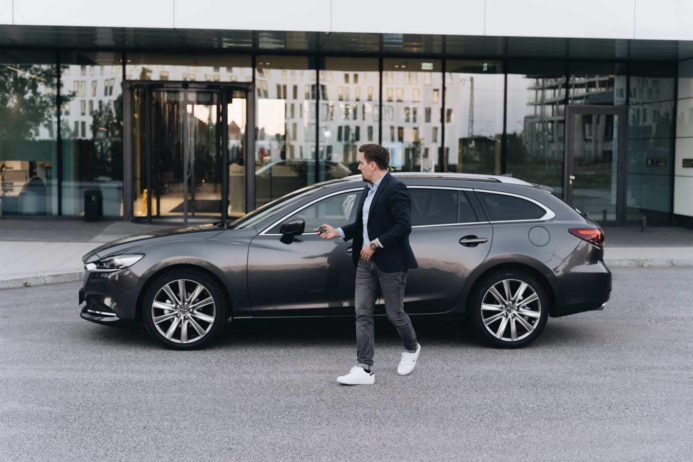 Ein Mann schließt ein FINN Auto ab und läuft vom Auto weg.