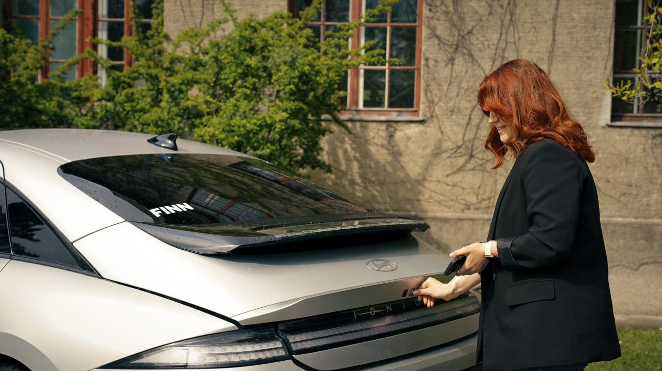 Eine Frau öffnet den Kofferraum eines Hyundai Ioniq 6.