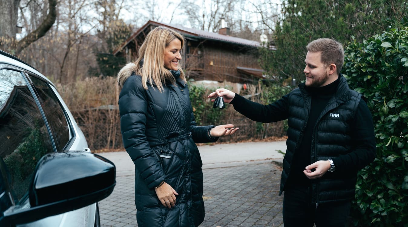 Ein Mann übergibt einer Frau einen Autoschlüssel.