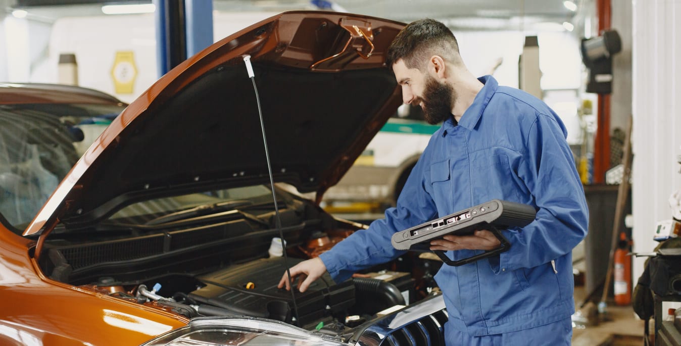 Ein Mechaniker überprüft ein Auto in Werkstatt zur Wartung und Inspektion.