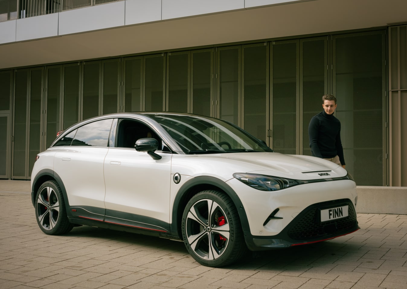 Ein Mann läuft neben einem smart #3 von FINN.