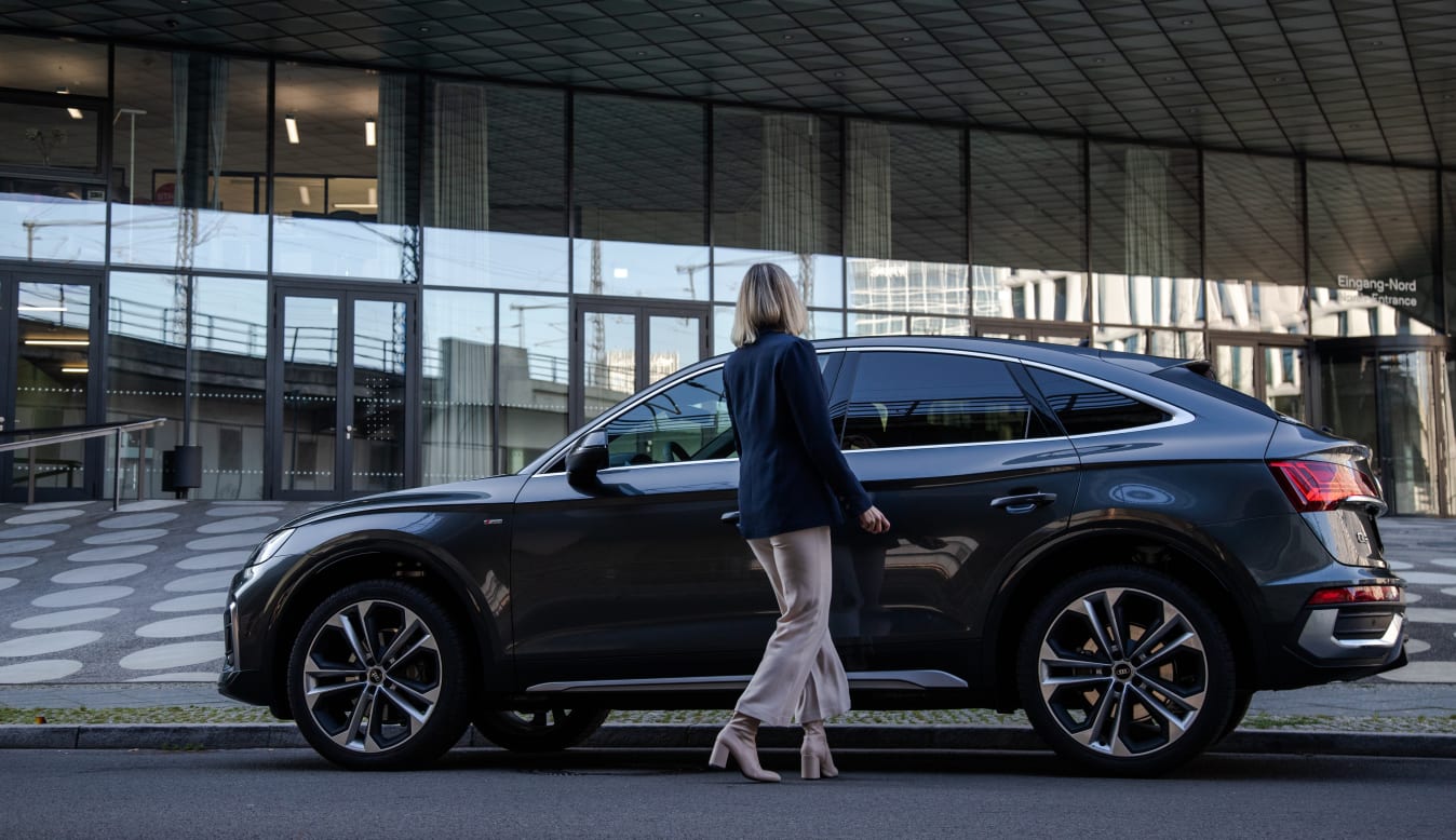 Frau steigt in den Audi Q5 von FINN ein.