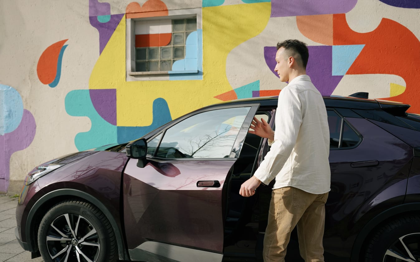 Ein Mann steigt in einen Toyota C-HR ein.