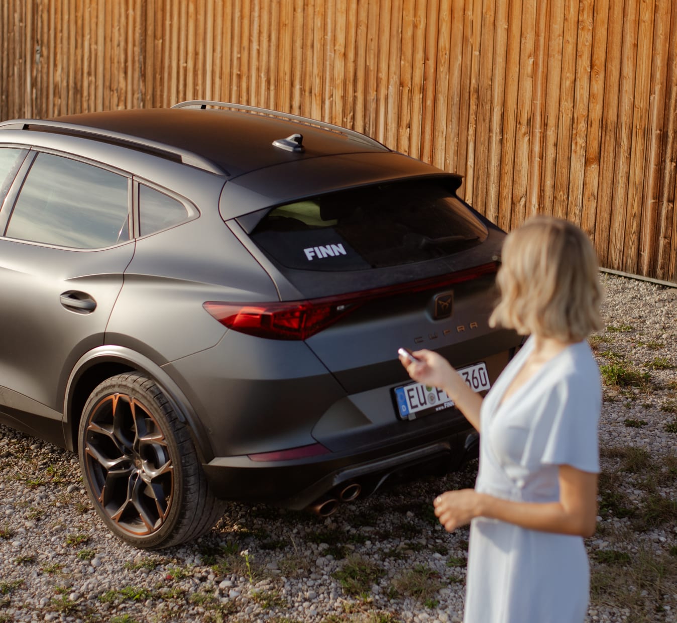 Frau neben einem Auto von FINN.