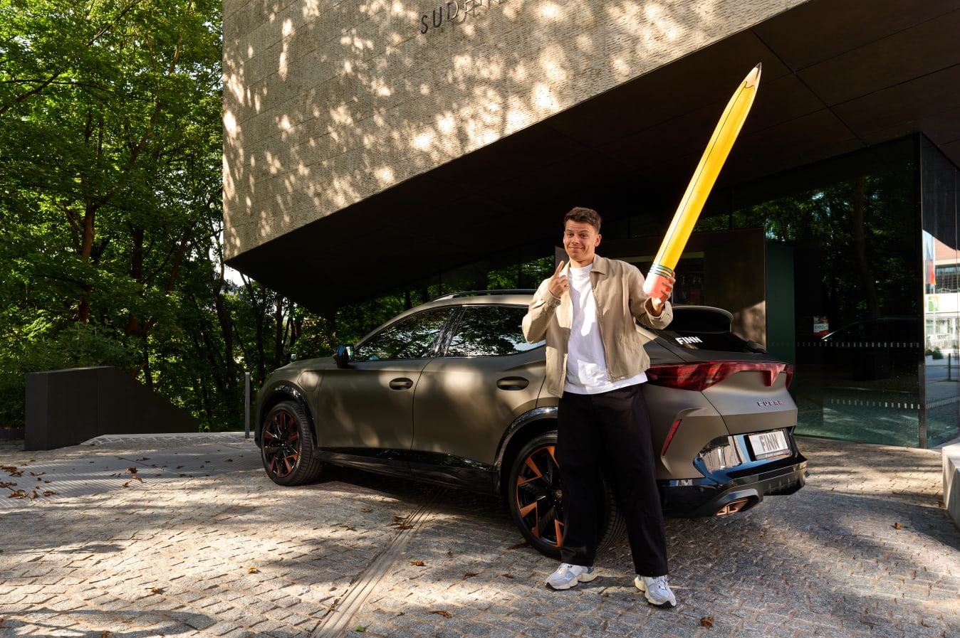 Ein Mann steht vor einem Cupra von FINN.