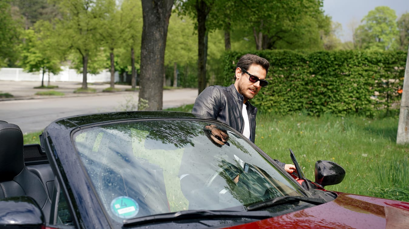 Ein Mann steigt in einen Mazda MX-5.