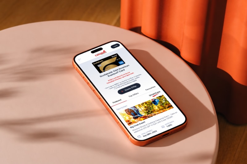 The Great Canadian Rebates app on a copper phone on a sunlit peach tabletop